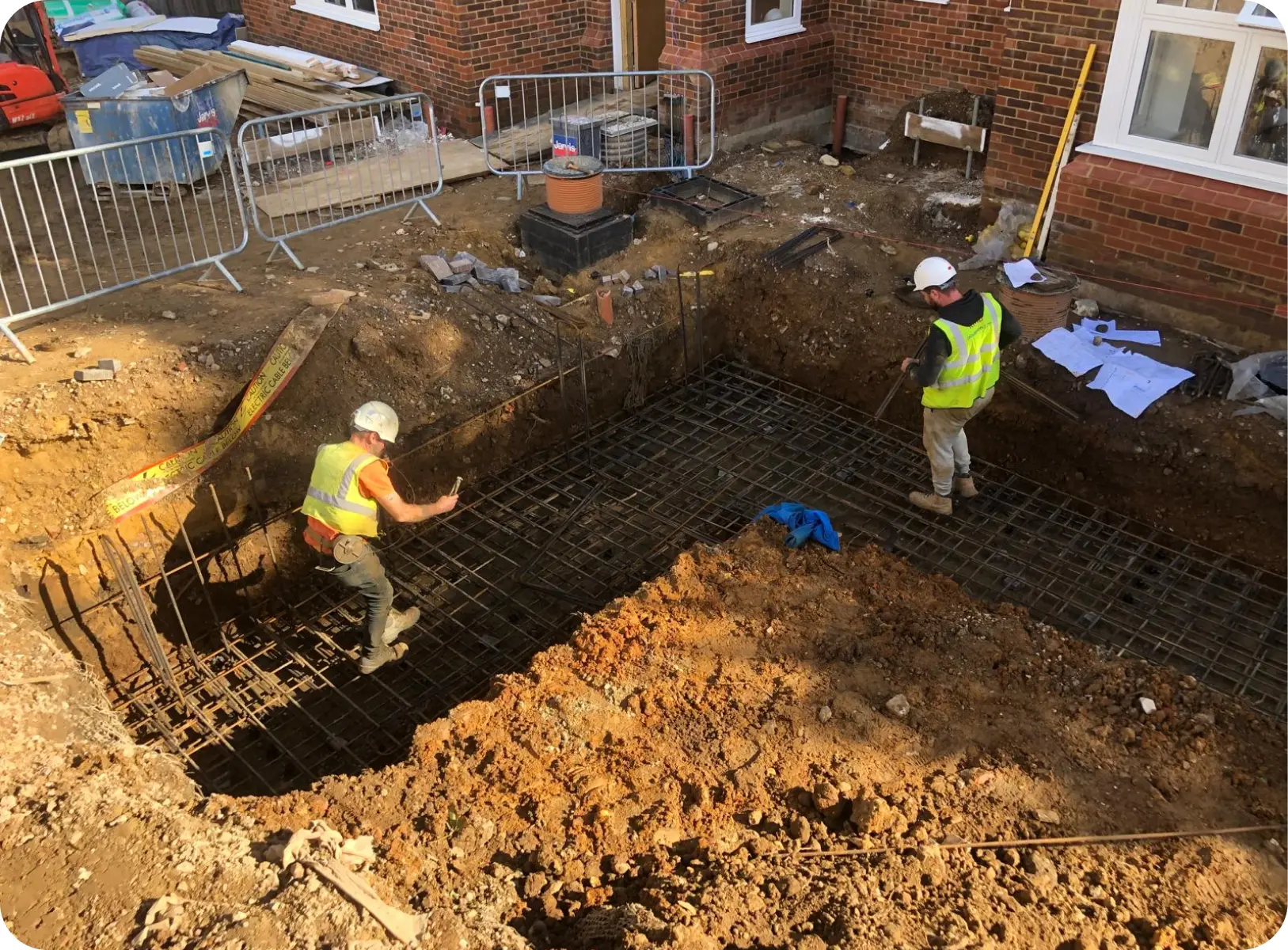 Operatives fixing reinforcement in a residential foundation excavation