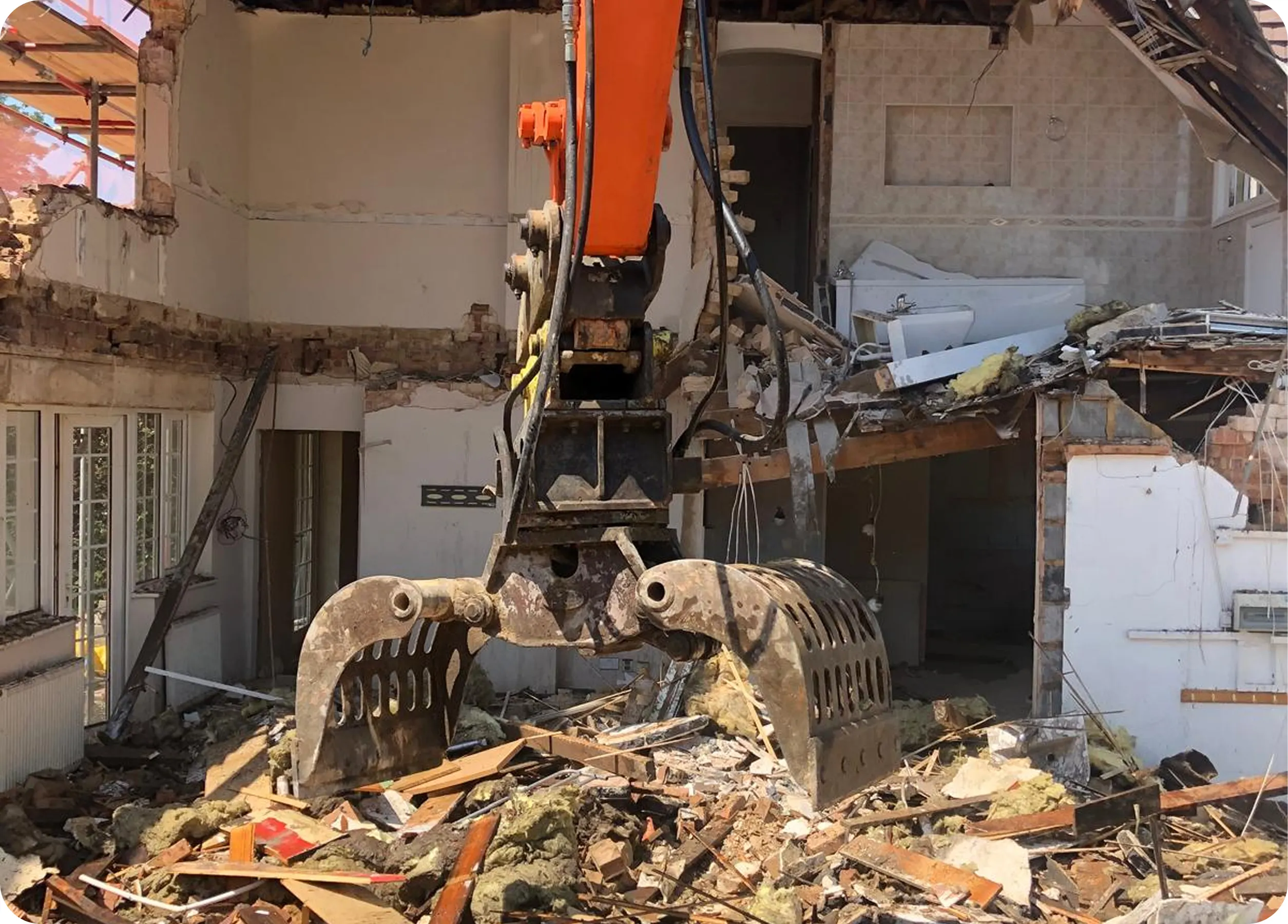 Excavator taking down an internal wall during demolition