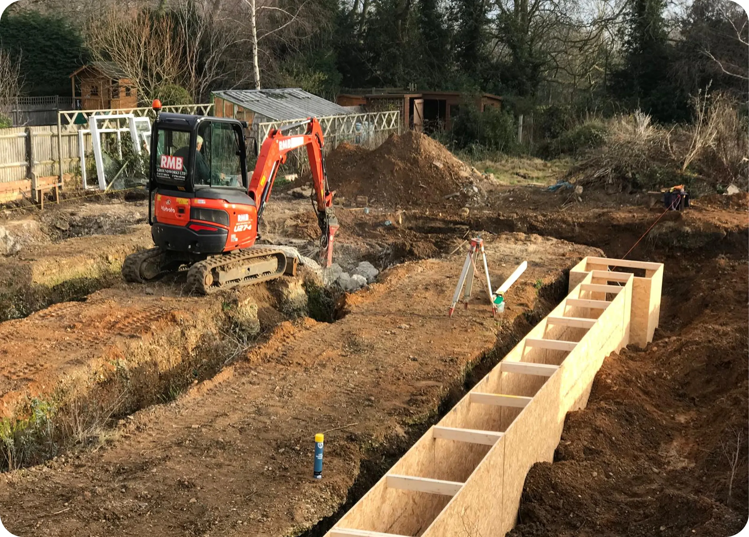 RMB mini excavator working beside foundation formwork
