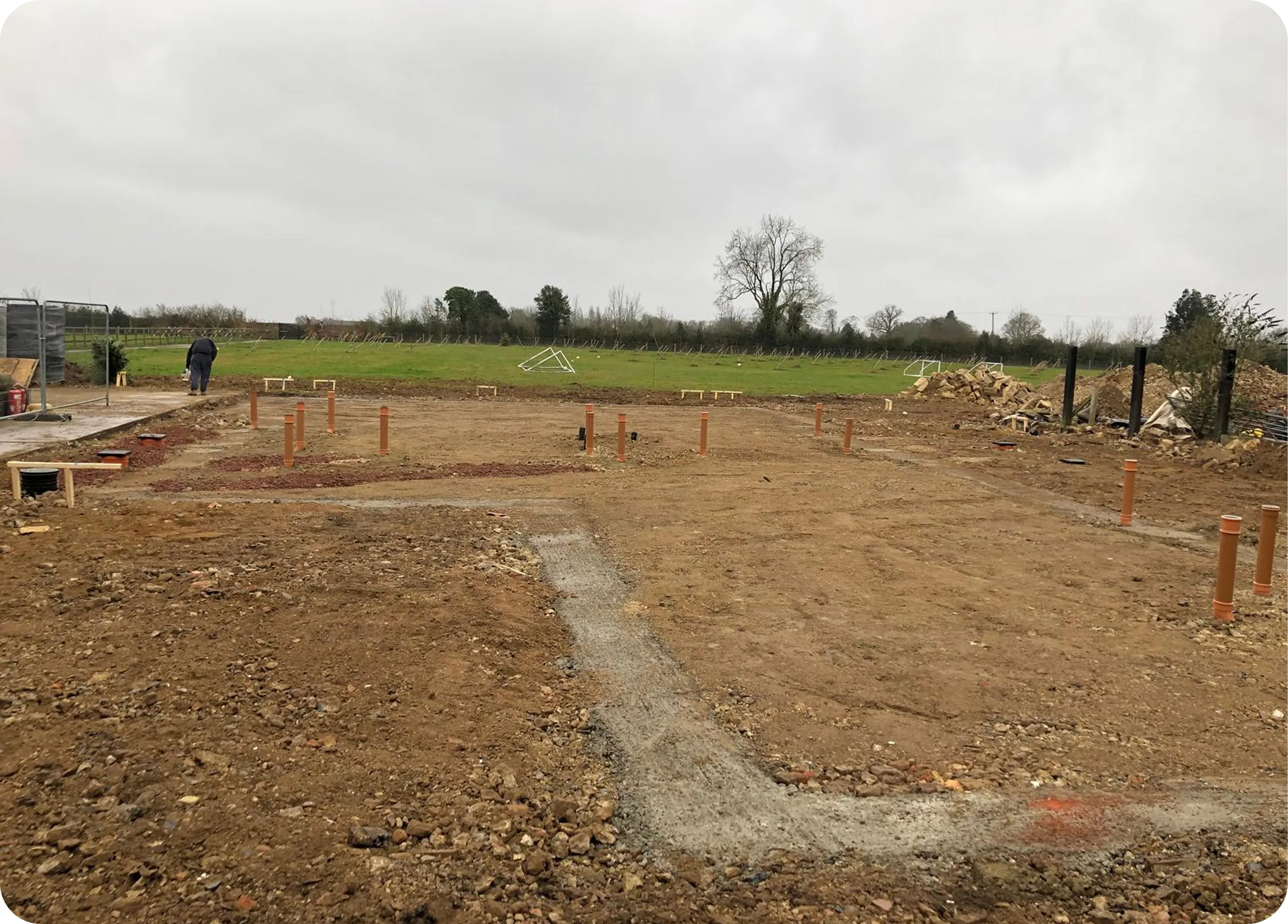 Site set out with drainage risers and a concrete path