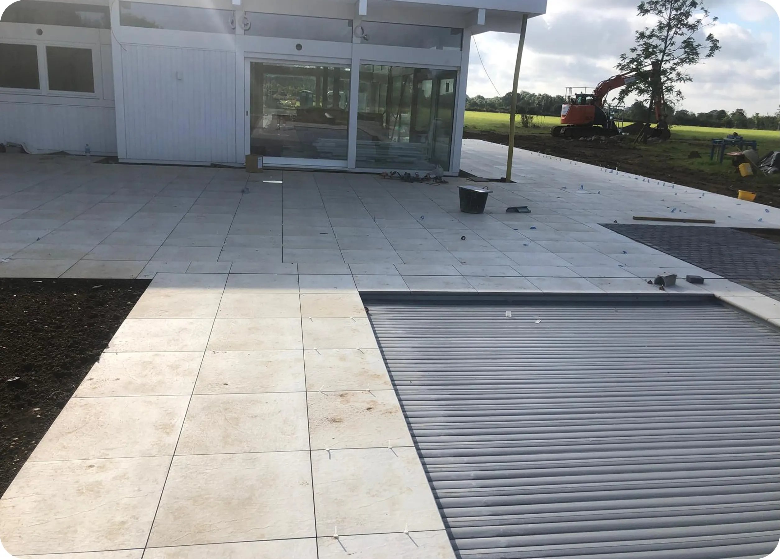 Large-format paving and a channel drain outside a new building