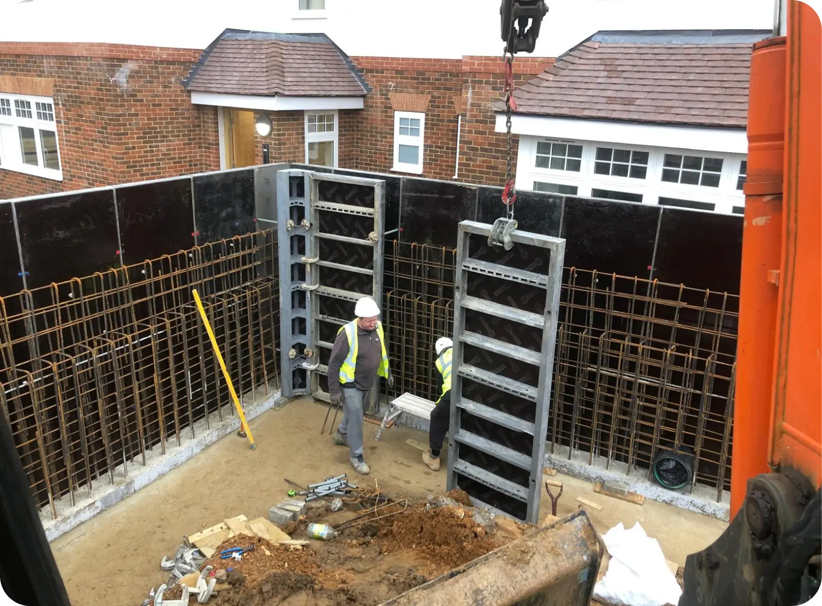 Steel formwork being lifted into a basement excavation