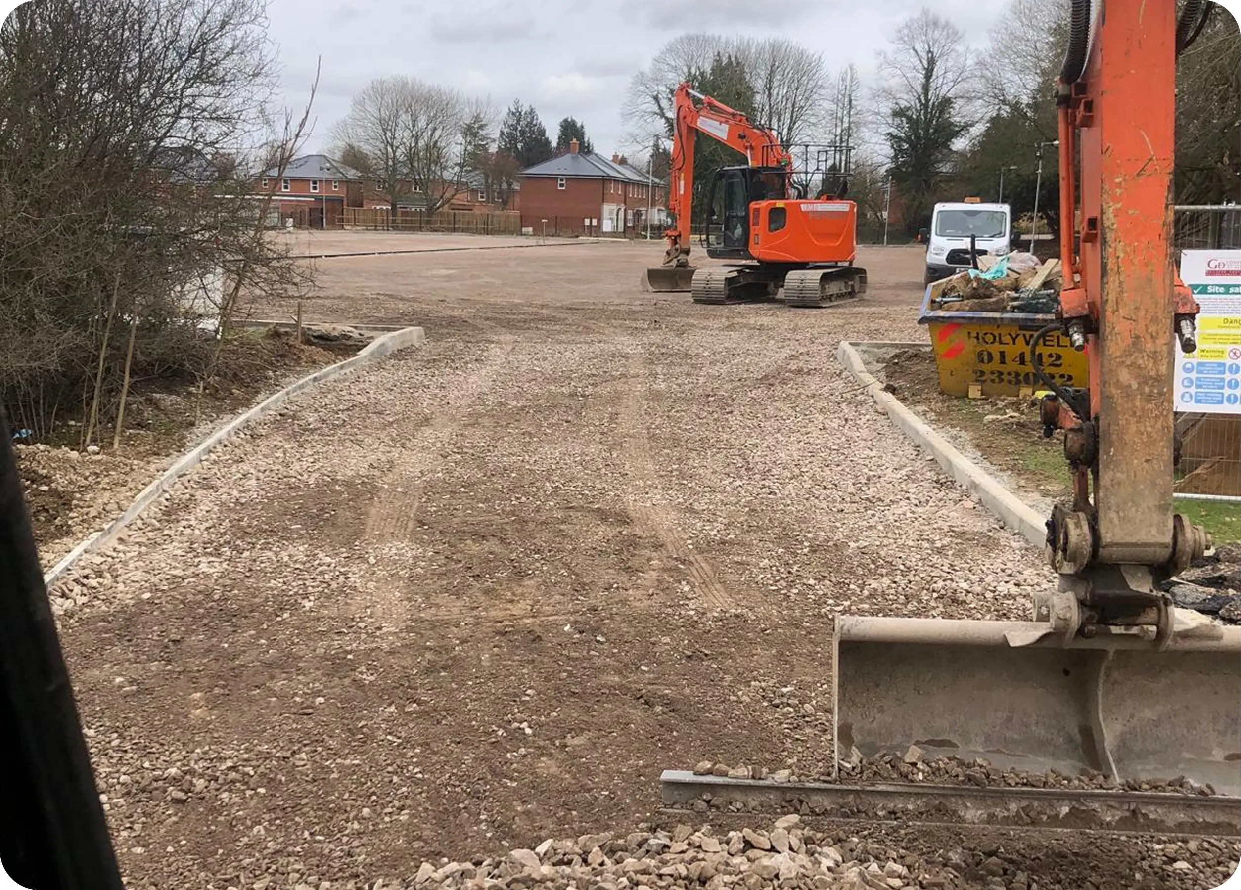 Kerbed access road with an RMB excavator on a cleared site