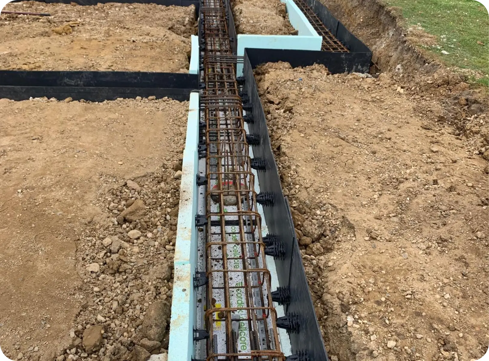 Reinforced ground beam trench prepared for concrete